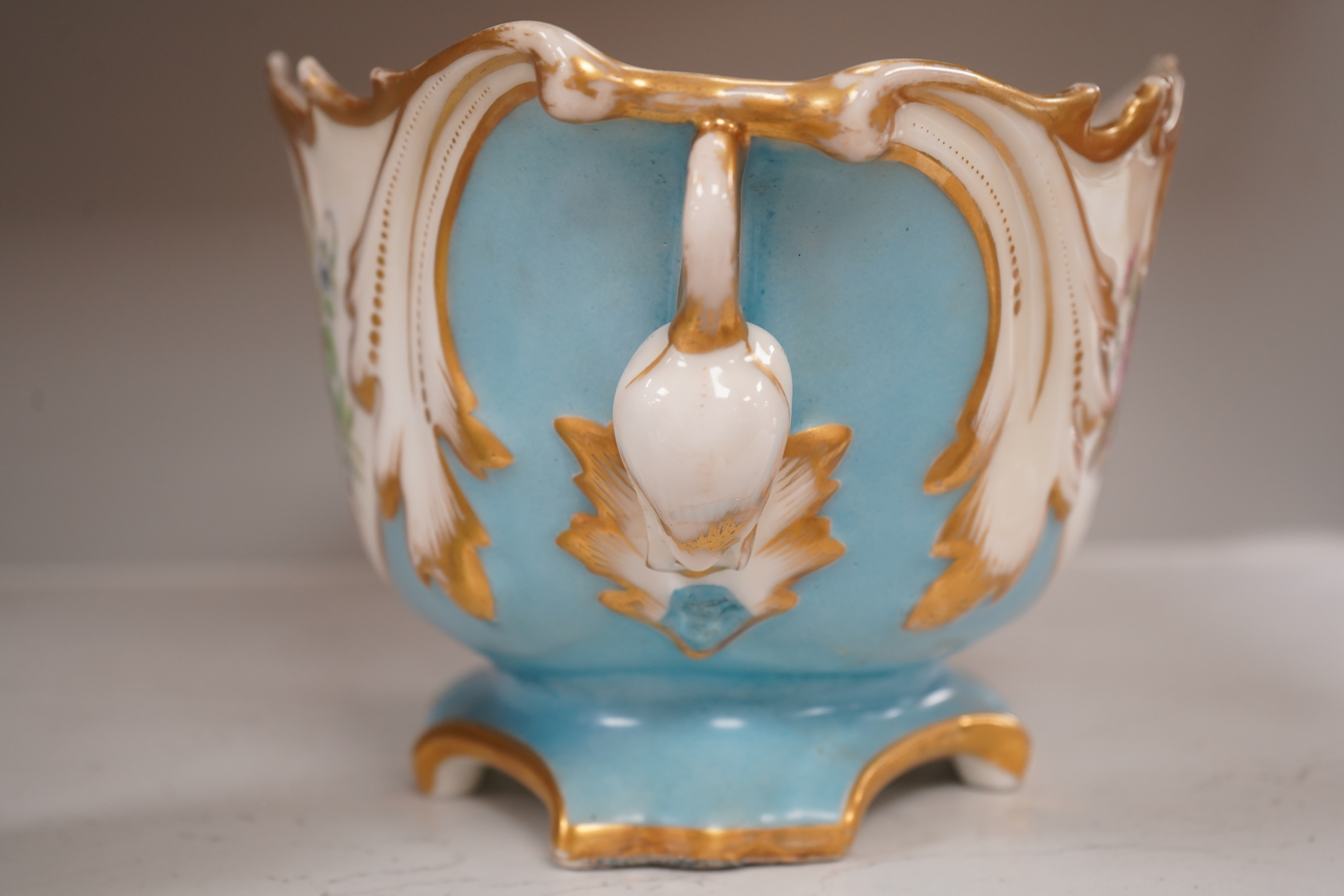 A Sevres style flower painted navette shaped jardiniere and a similar French scent bottle and stopper, late 19th century, largest 38cm wide. Condition - fair to good